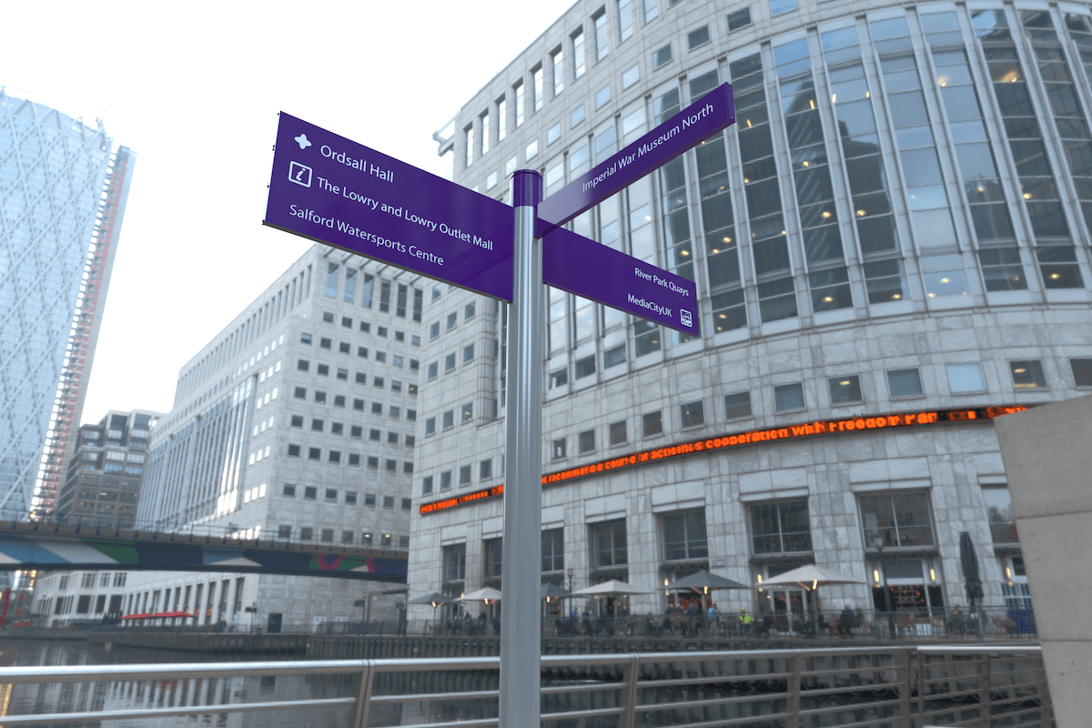 Purple fingerpost signage in central London with large buildings in the background